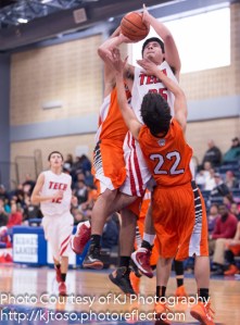 Fox Tech's Ruben Hernandez draws contact from two Burbank players, but scores two points.