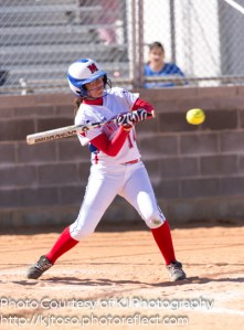 Memorial's Esther Martinez (14) takes a cut at Nikki Velasquez's pitch.