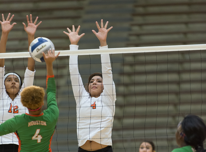 Two unidentified Burbank players put up a block against Sam Houston's Rita Davis.