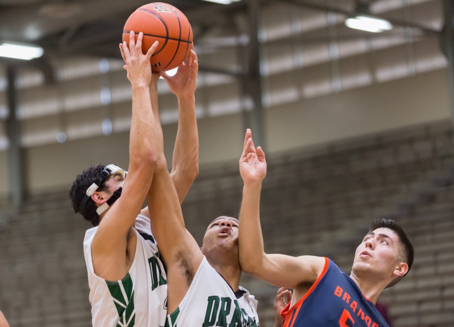 Southwest's Brandon Munoz (32) and Aaron Embry (33) grab a rebound over the Broncos' Ray Gallardo Jr.