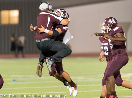 A Highlands assistant coach and player celebrate the Owls' 14-7 victory.